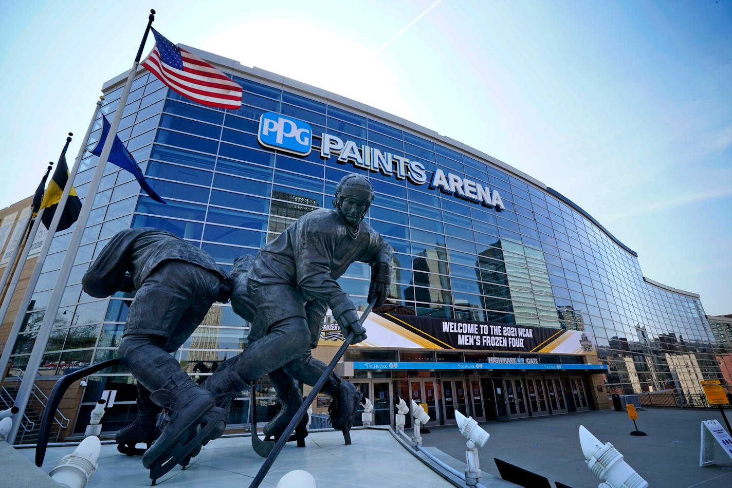 A statue of Pittsburgh Penguins Hockey Hall of Fame center Mario Lemieux, left, stands in front of the PPG Paints Arena, the site of the 2021 NCAA Men's Frozen Four