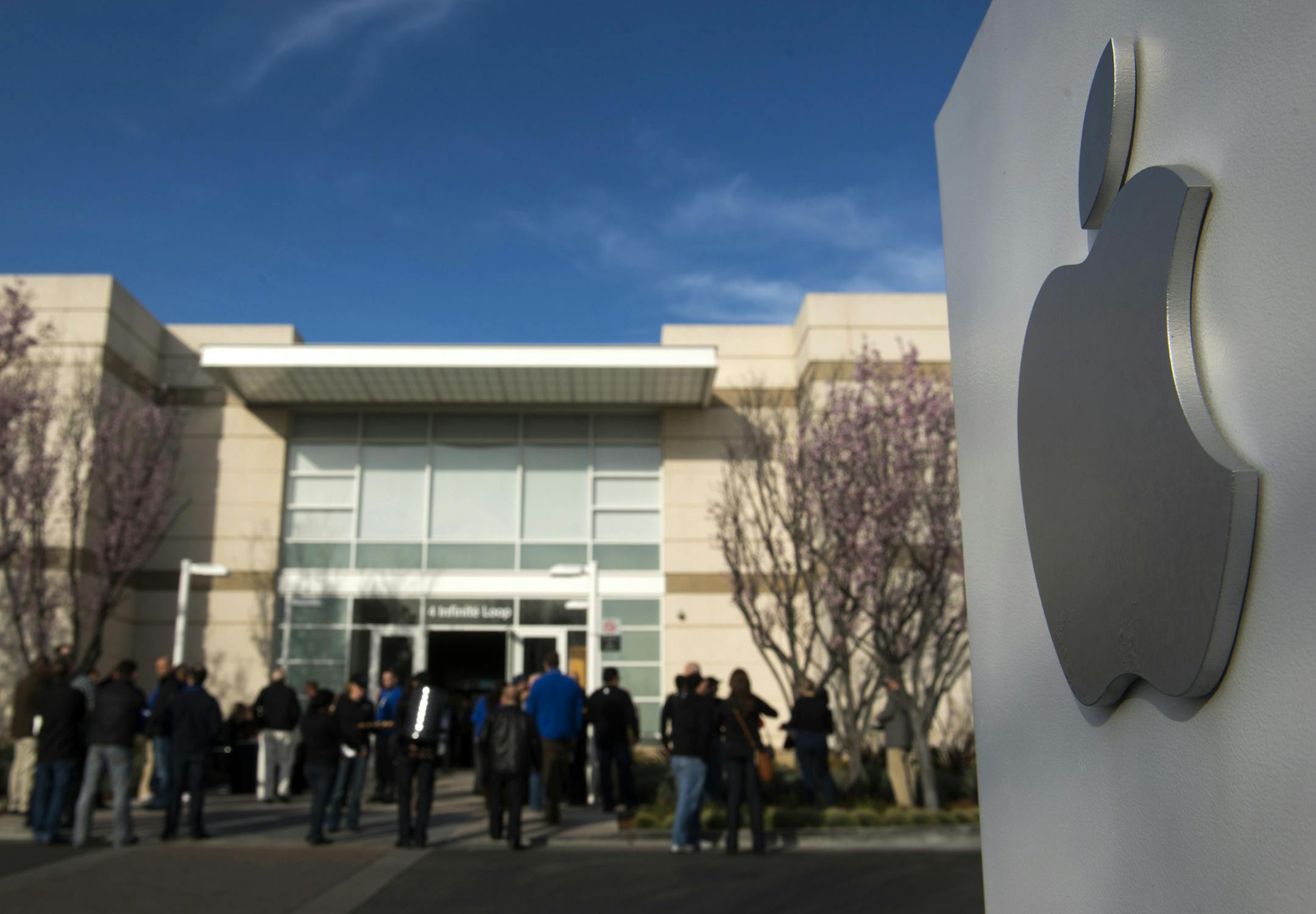 Attendees arrive at the Apple Inc. shareholders meeting at the company's headquarters in Cupertino, California, U.S., on Wednesday, Feb. 27, 2013. As Apple Inc. Chief Executive Officer Tim Cook takes the stage at this year‚Äôs shareholder meeting, he may not get the reception he received in 2012, when investors lauded the company's performance and rising shares. Photographer: David Paul Morris/Bloomberg ORG XMIT: 162928421