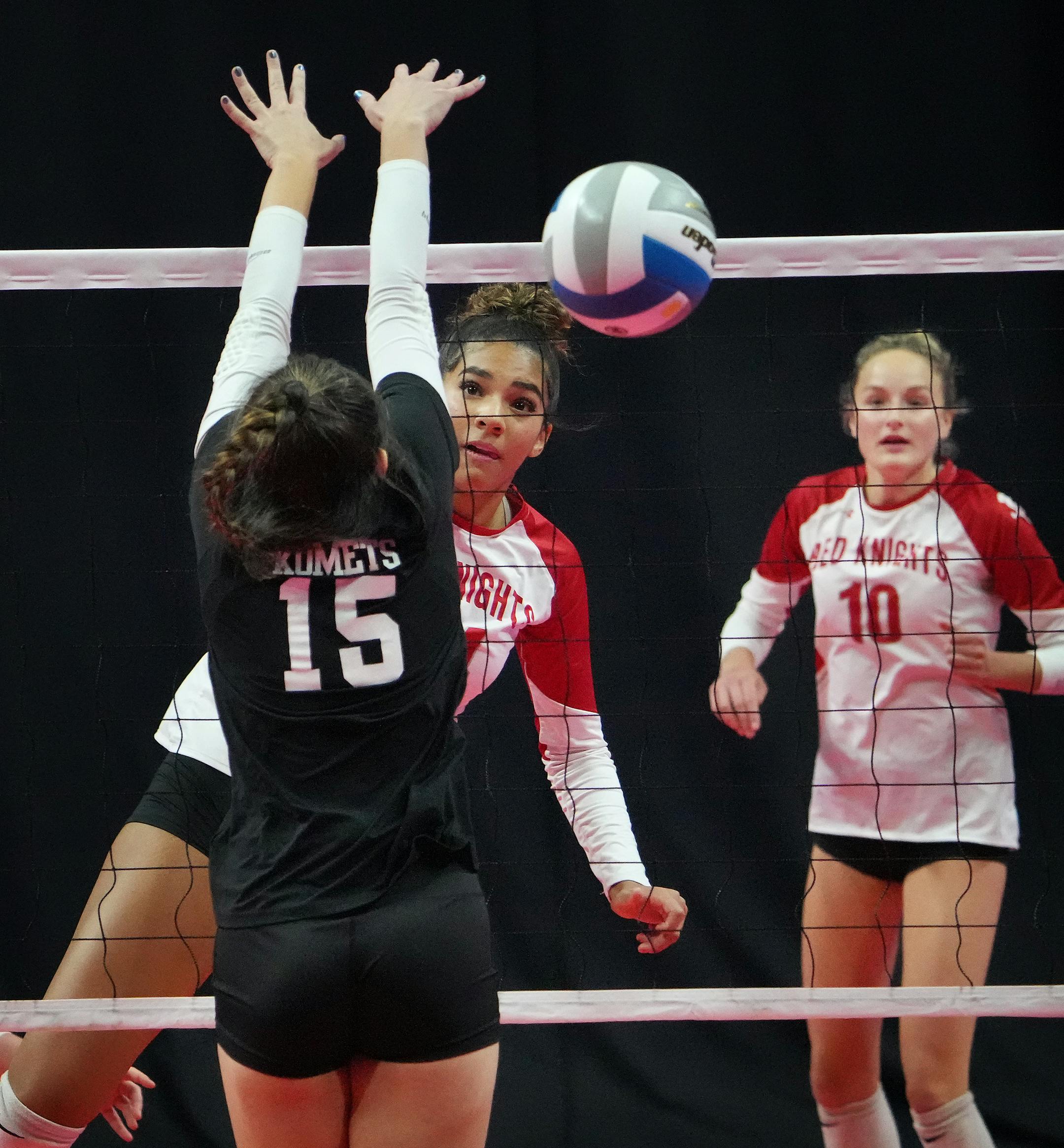 Benilde-St. Margaret's Sierre Lumpkin (24) spikes a shot past Kasson-Mantorville's Sophie Sutton (15) as Benilde-St. Margaret's Lily Eigner (10) looks on.