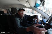 Uber driver Mohamed Egal checks the app on his phone to accept a rider on Feb. 16 in Minneapolis.