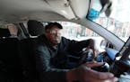 Uber driver Mohamed Egal checks the app on his phone to accept a rider on Friday, Feb. 16, 2024 in Minneapolis.