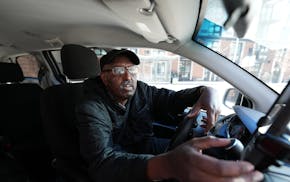 Uber driver Mohamed Egal checks the app on his phone to accept a rider on Feb. 16 in Minneapolis.