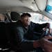 Uber driver Mohamed Egal checks the app on his phone to accept a rider on Feb. 16 in Minneapolis.