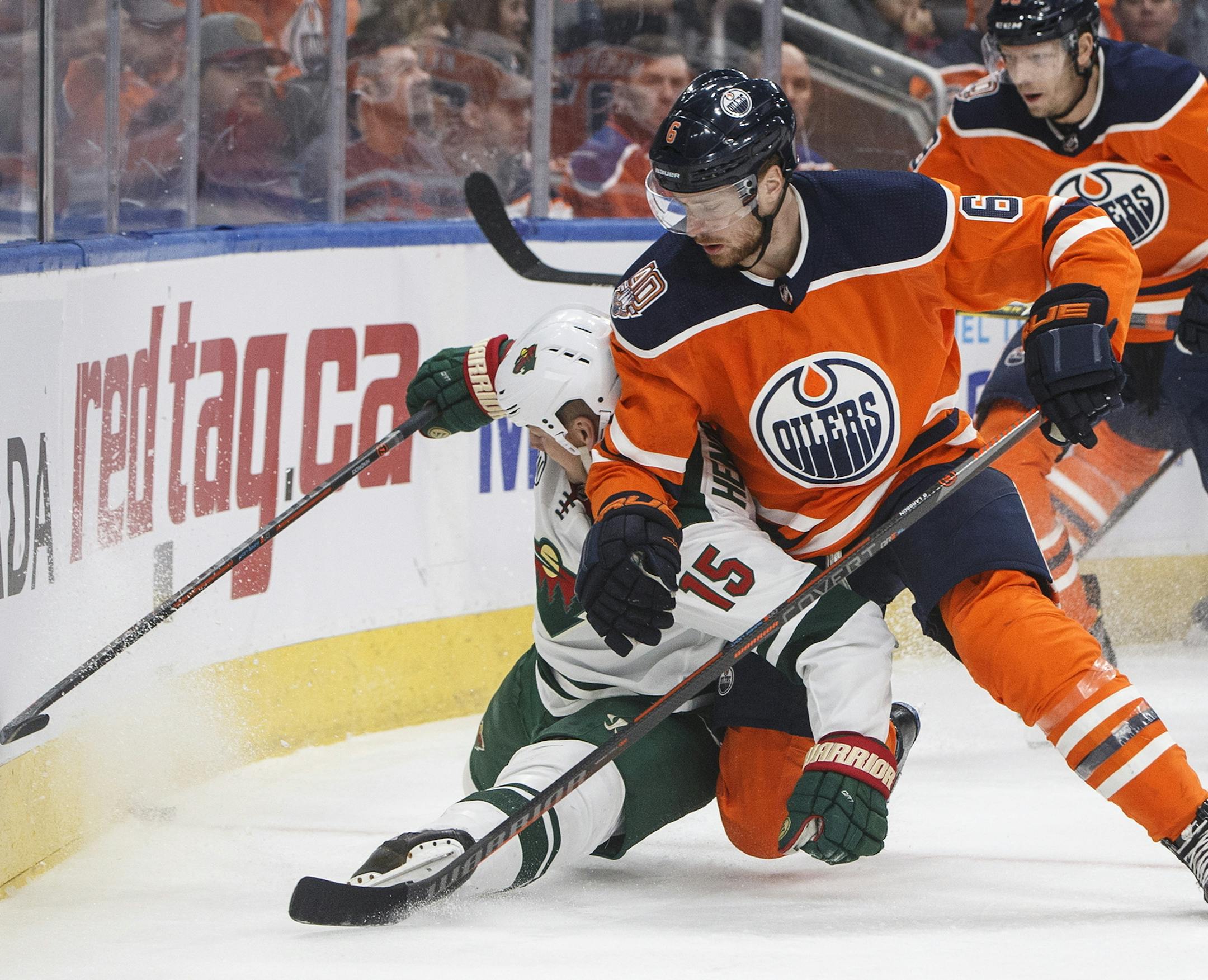 Minnesota Wild's Matt Hendricks (15) is checked by Edmonton Oilers' Adam Larsson (6) during first-period NHL hockey game action in Edmonton, Alberta, Friday, Dec. 7, 2018.(Jason Franson/The Canadian Press via AP)