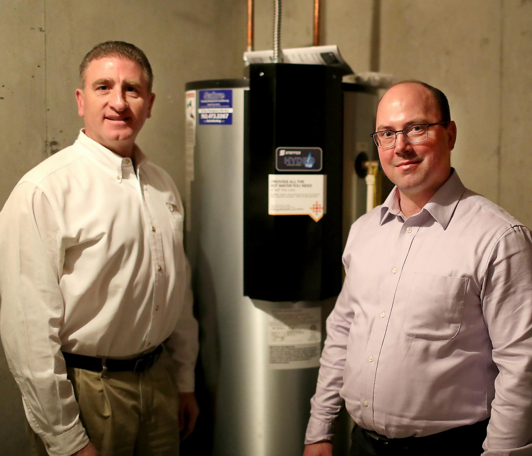 Dave Reinke of Dakota Electric Association, and Jeff Haase of Great River Energy have worked together to bring new technology to a subdivision in Lakeville equipped with smart water heaters that cut electric costs by two thirds. Here, Dave Reinke, left, and Jeff Haase are pictured next to a Steffe's Hydro Plus water heater, a grid enabled electric thermal storage unit, which plugs into technology to store renewable energy. and seen Thursday, Feb. 15, 2018, in Lakeville, MN.] DAVID JOLES •