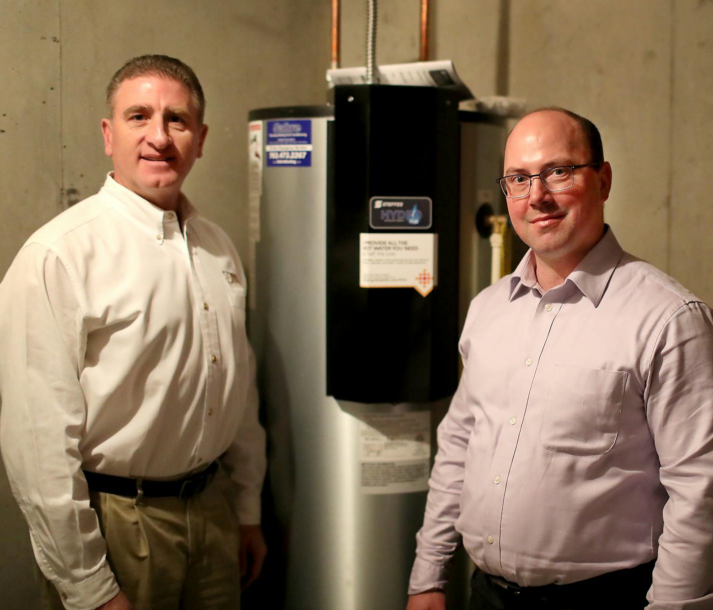 Dave Reinke of Dakota Electric Association, and Jeff Haase of Great River Energy have worked together to bring new technology to a subdivision in Lakeville equipped with smart water heaters that cut electric costs by two thirds. Here, Dave Reinke, left, and Jeff Haase are pictured next to a Steffe's Hydro Plus water heater, a grid enabled electric thermal storage unit, which plugs into technology to store renewable energy. and seen Thursday, Feb. 15, 2018, in Lakeville, MN.] DAVID JOLES &#x2022;