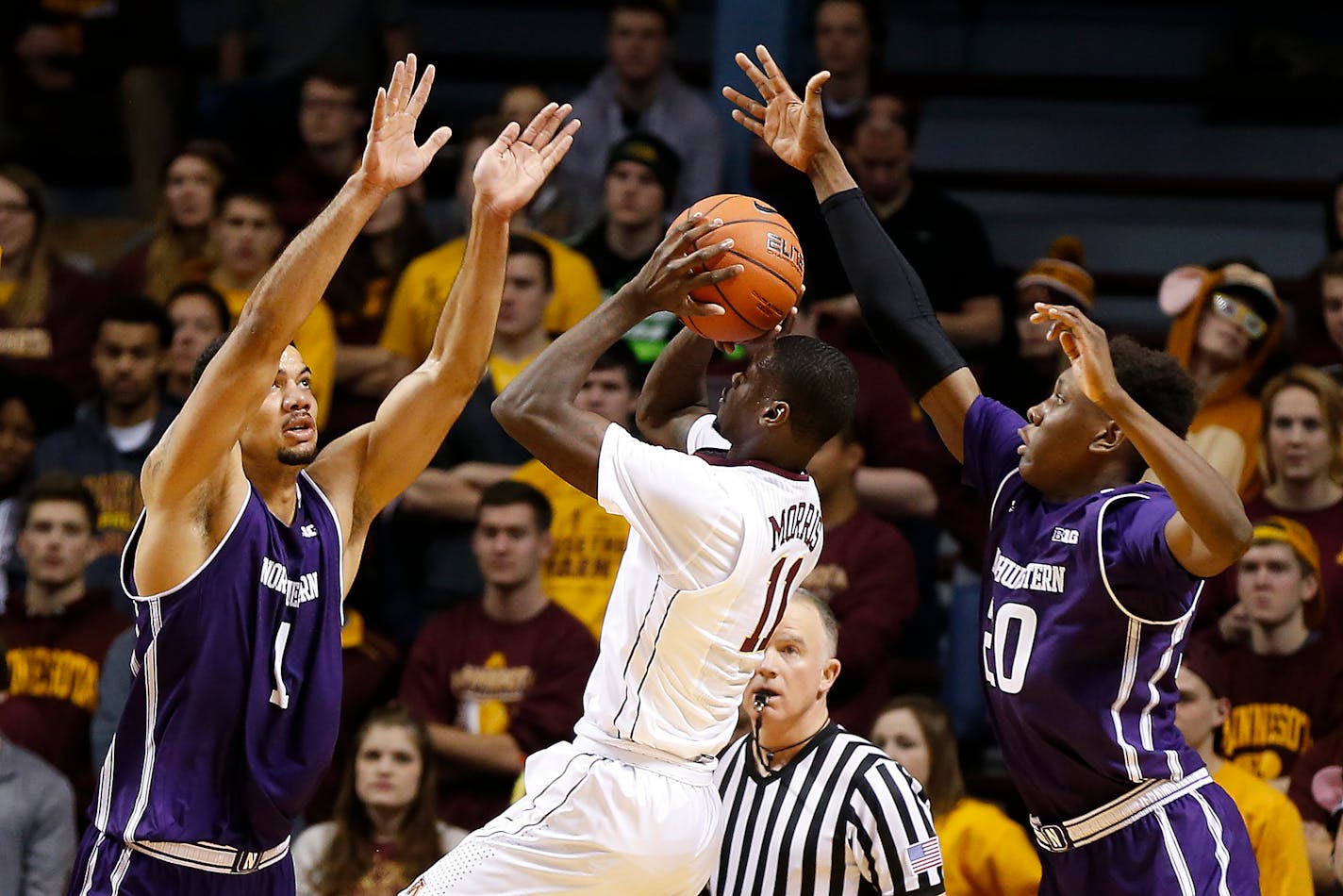 Minnesota guard Carlos Morris (11) shoots the ball as Northwestern center Joey van Zegeren (1) and guard Scottie Lindsey (20) defend in the first half of an NCAA college basketball game, Saturday, Jan. 9, 2016, at Williams Arena in Minneapolis. (AP Photo/Stacy Bengs)