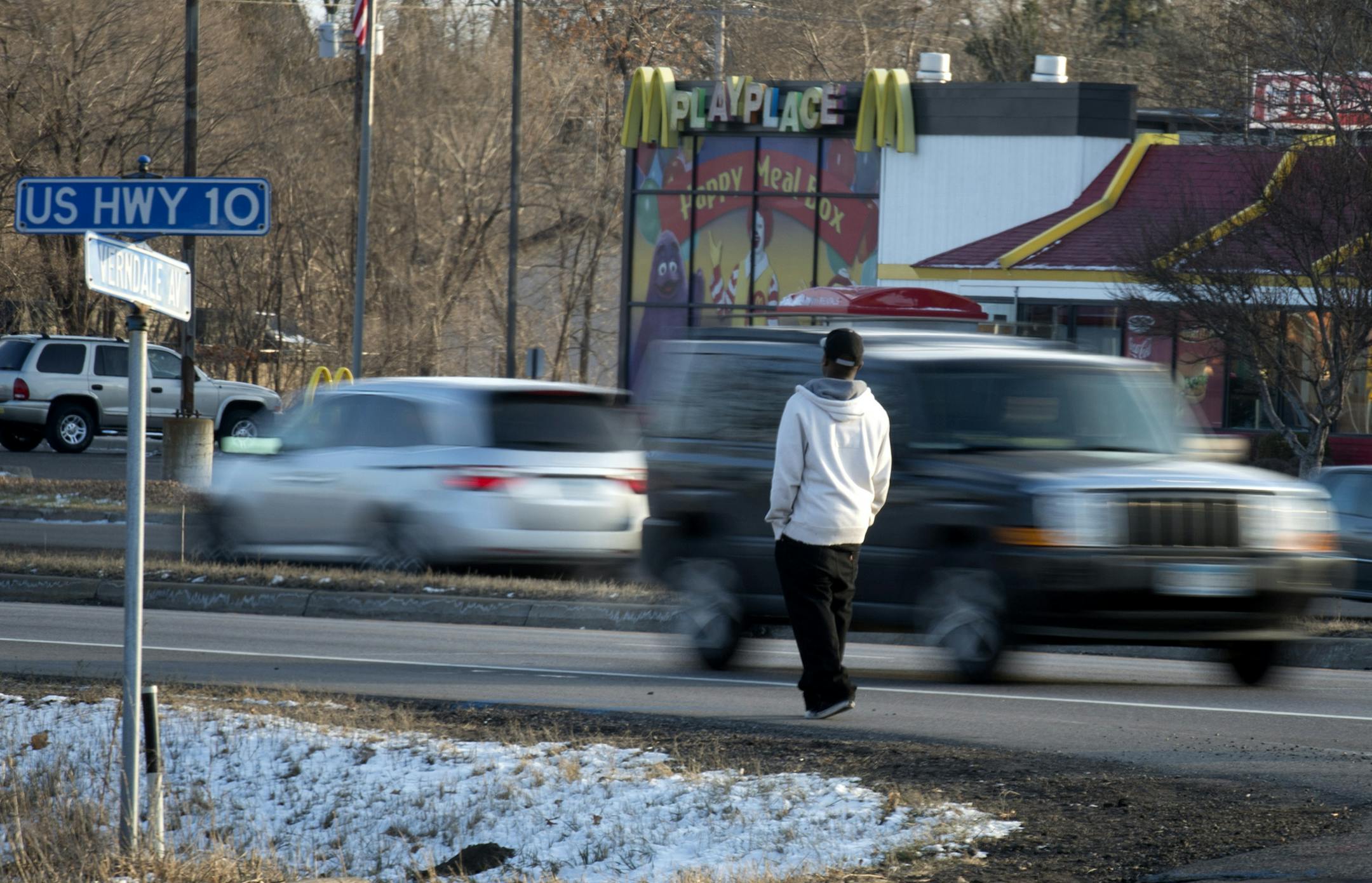 A pedestrian waited for an opportunity to cross busy State Highway 10 in Anoka at Verndale Ave near the location where Hannah Craft, 16, was killed Monday night while crossing the same road on her way to work at the McDonalds across the street. Tuesday, November 27, 2012. ] GLEN STUBBE * gstubbe@startribune.com