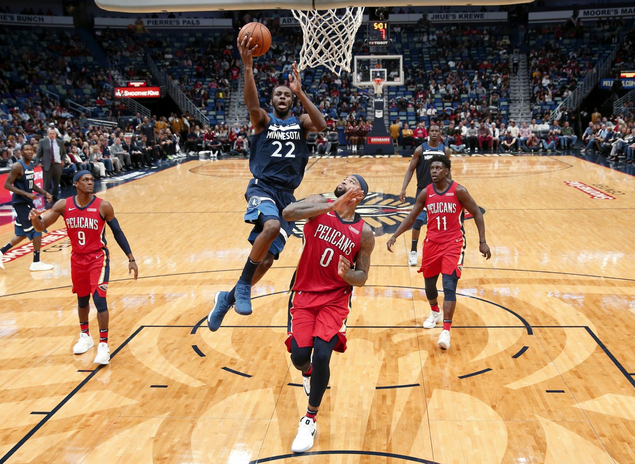Minnesota Timberwolves forward Andrew Wiggins (22) goes to the basket over New Orleans Pelicans center DeMarcus Cousins (0) during the second half of an NBA basketball game in New Orleans, Wednesday, Nov. 29, 2017. The Timberwolves won 120-102.