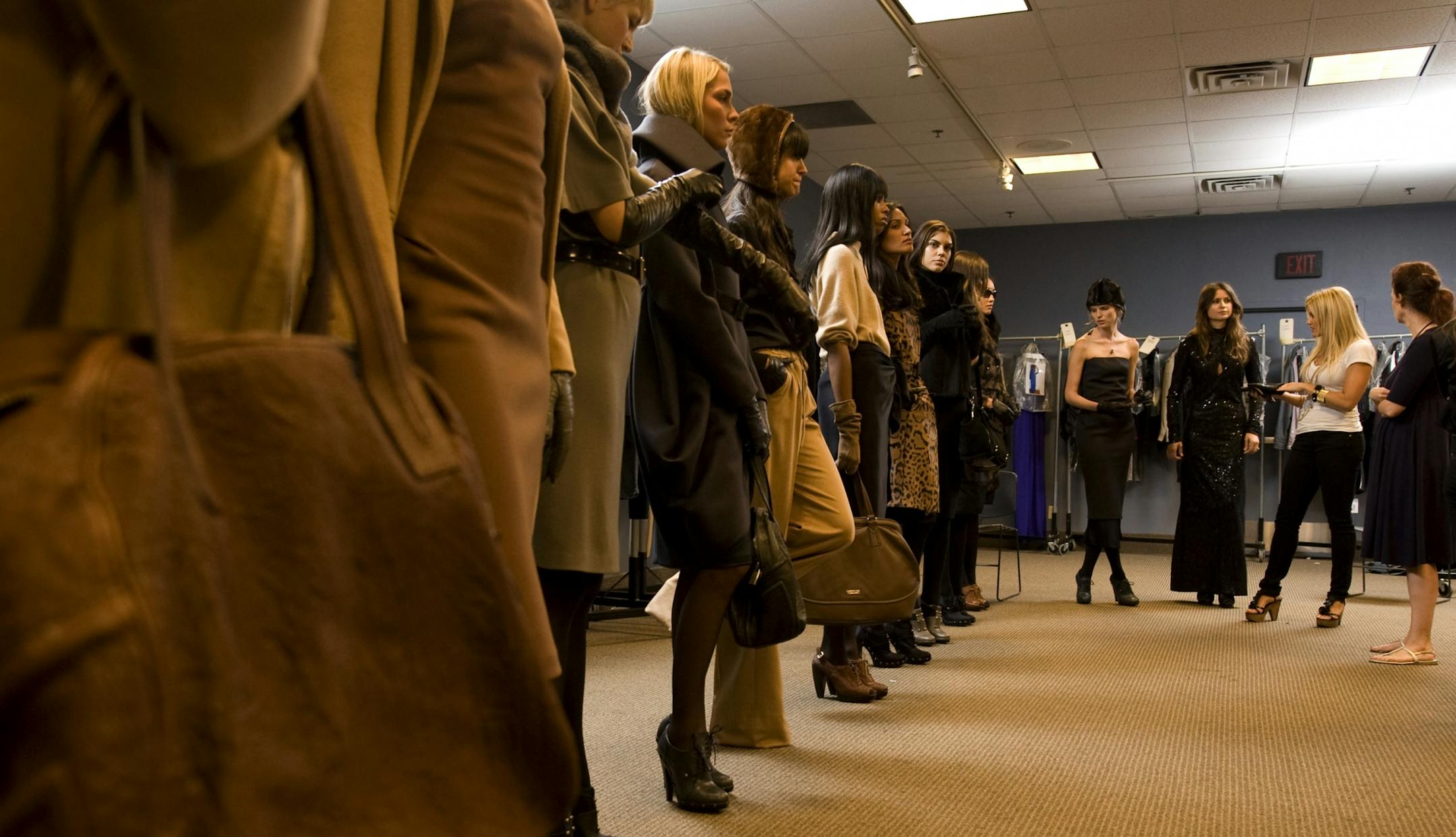 Laura Schara, fashion director, and Cindy Warner (blue dress right) look over a lineup of clothes on models on Macy's 12th floor in preparation for the Glamorama fashion blow-out.