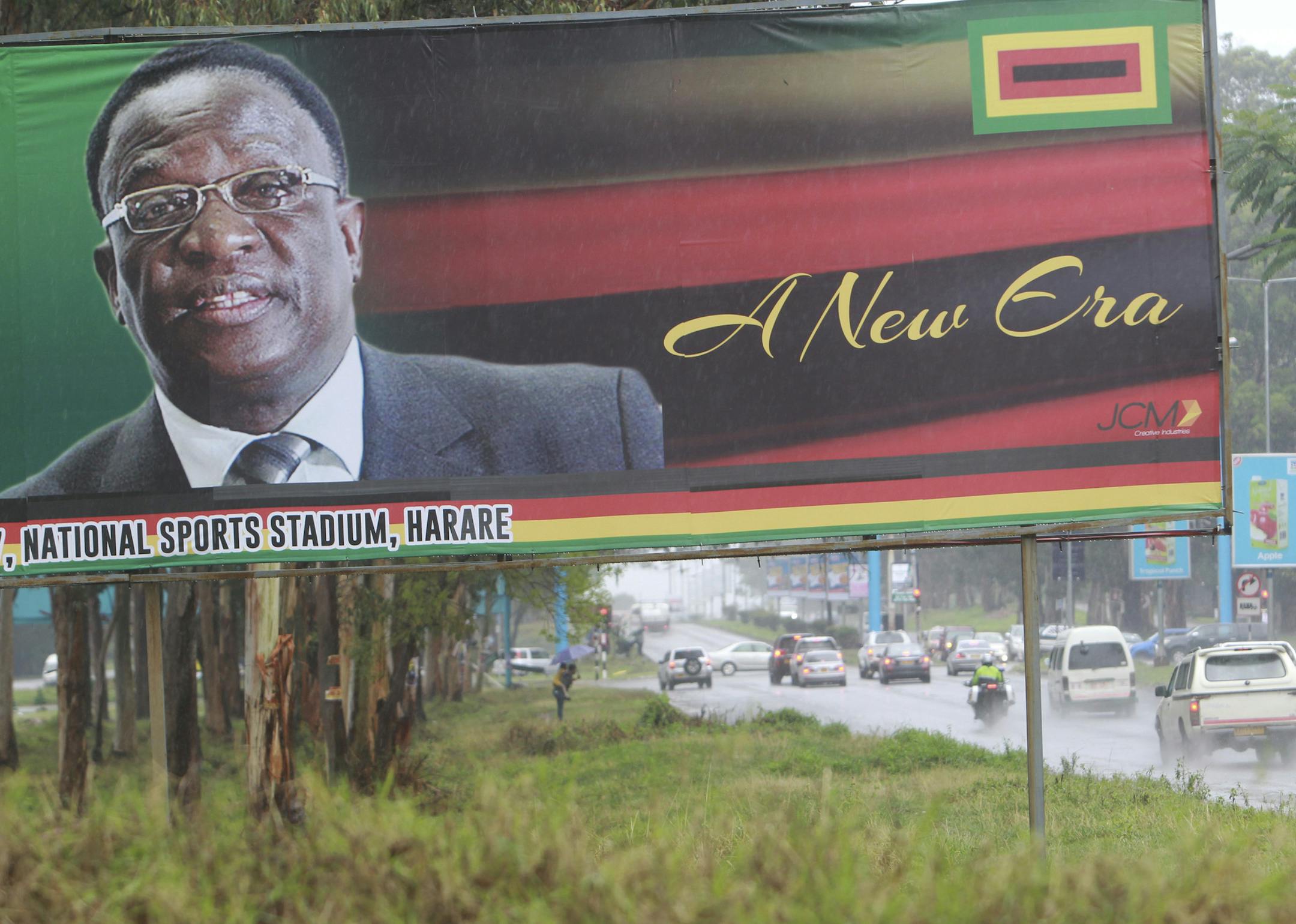 Traffic flows past a billboard with a portrait of Emmerson Mnangagwa the new Zimbabwean President in Harare, Zimbabwe, Monday, Nov.27, 2017. Zimbabwe's security forces said in a joint statement Monday that the "situation in our country had returned to normalcy", after a crisis during which the military staged a takeover and crowds demonstrated against Mugabe at the end of his 37 year rule.(AP Photo/Tsvangirayi Mukwazhi)