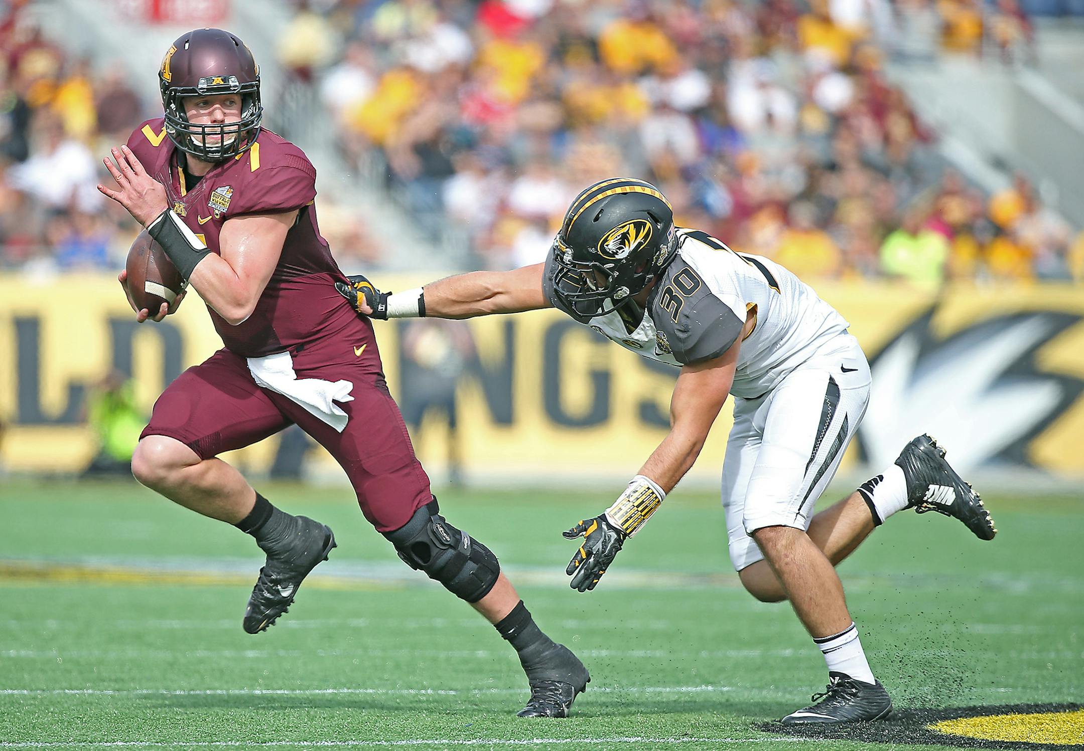 Minnesota's quarterback Mitch Leidner (7) ran for yards despite pressure from Missouri's linebacker Michael Scherer (30) during the first quarter of the Citrus Bowl at Citrus Bowl Stadium, Thursday, January 1, 2015 in Orlando, FL. ] (ELIZABETH FLORES/STAR TRIBUNE) ELIZABETH FLORES � eflores@startribune.com
