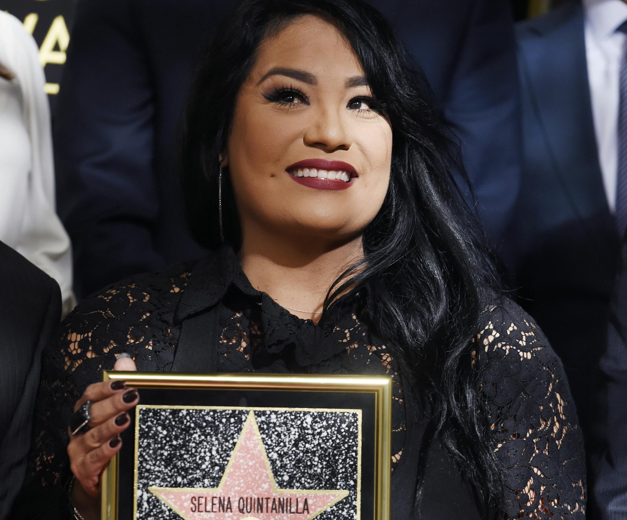 Suzette Quintanilla, sister of the late singer Selena Quintanilla, holds a replica of her sister's star on the Hollywood Walk of Fame during a posthumous star ceremony on Friday, Nov. 3, 2017, in Los Angeles. (Photo by Chris Pizzello/Invision/AP)