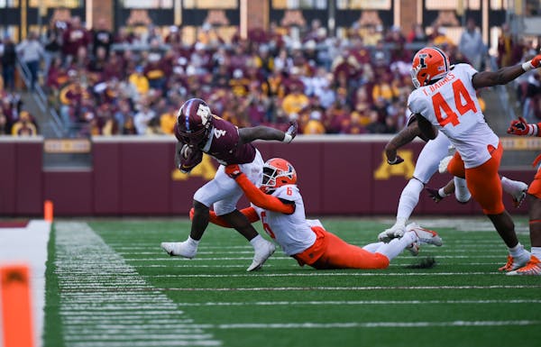 Minnesota Gophers running back Mar'Keise Irving (4) runs the ball for a first down as Illinois defensive back Tony Adams (6) gets the tackle during th