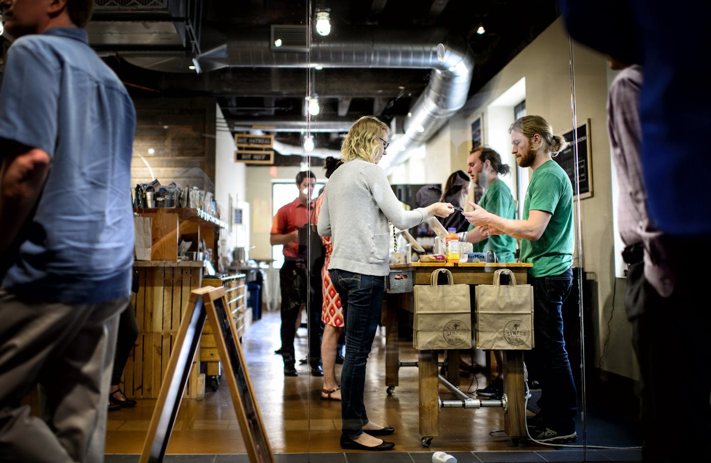 Ryan Rosenthal, right, worked the register at lunchtime. Rosenthal, the owner of Simpls works 60 hours sometimes. He doesn't have a manager, but if he did he says it would be difficult to pay him or her overtime. ] GLEN STUBBE * gstubbe@startribune.com Tuesday, July 1, 2015