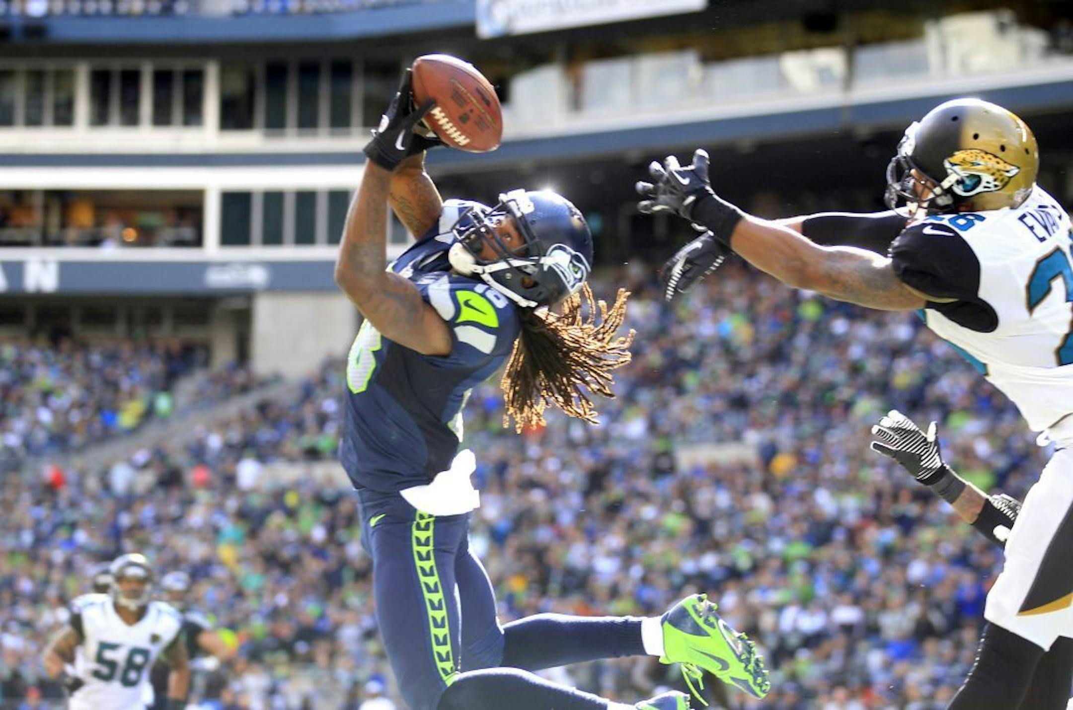 Seattle Seahawks' Sidney Rice, front left, snags the ball in the end zone for a touchdown in front of Jacksonville Jaguars' Josh Evans in the second half of an NFL football game on Sunday, Sept. 22, 2013, in Seattle.