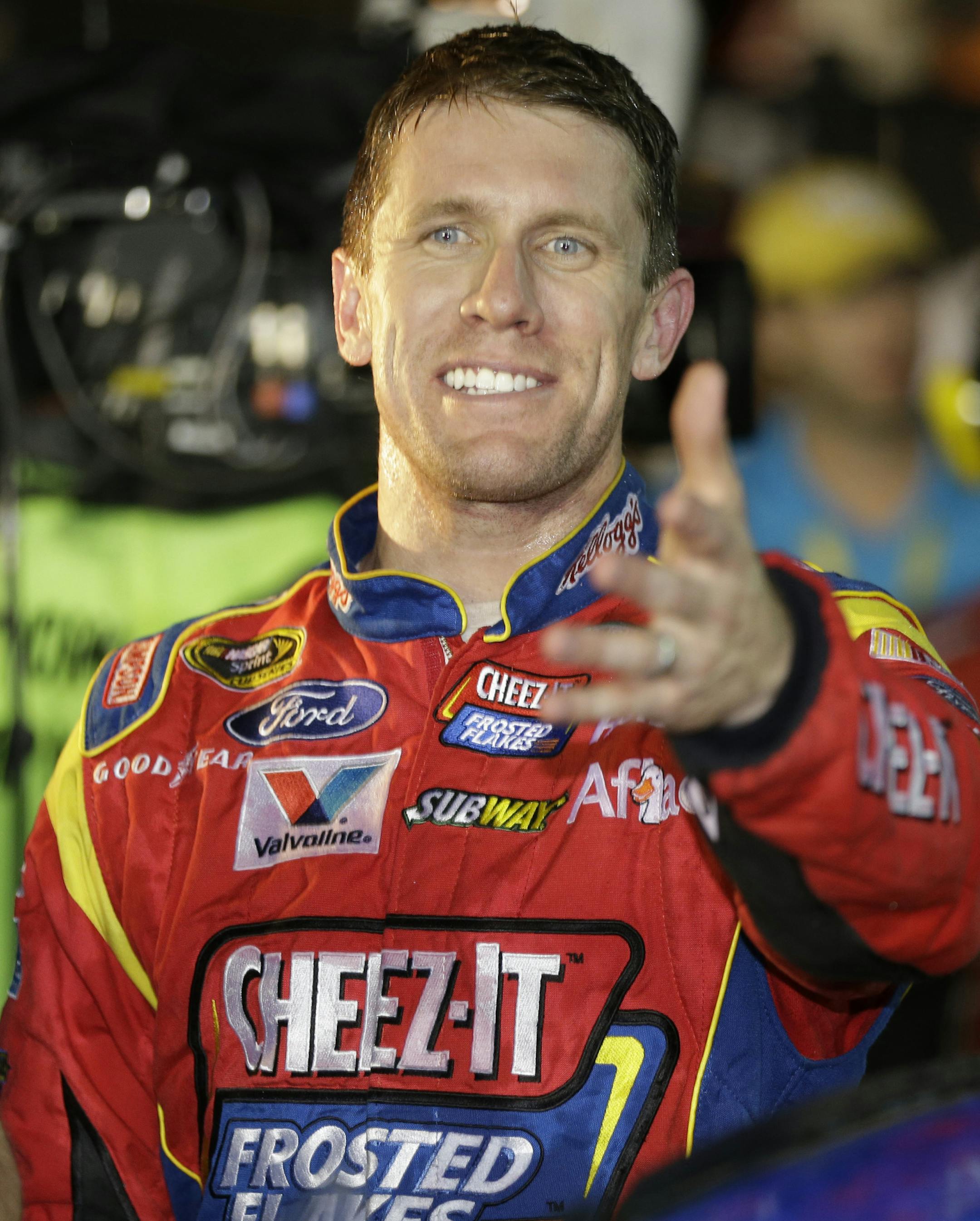 Carl Edwards smiles as he celebrates winning the NASCAR Sprint Cup Series auto race at Richmond International Raceway in Richmond, Va., Saturday, Sept. 7, 2013. (AP Photo/Steve Helber)