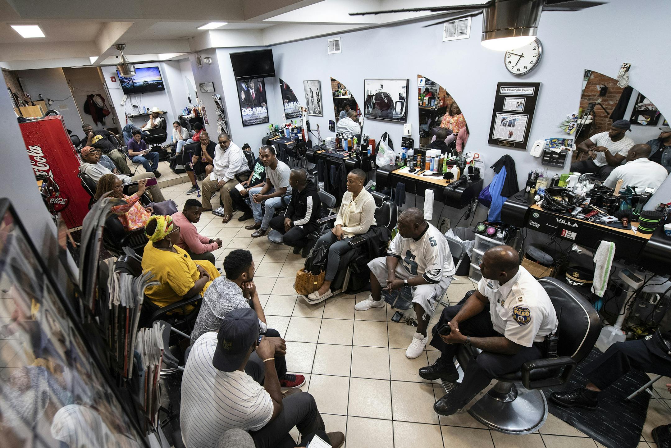 Philadelphia Police and residents gather during a meeting called "Blades, Fades, and Engage" at the Philly Cuts barbershop in Philadelphia on September 17, 2018. Stewart, organized the event at a West Philly barbershop, where members of the community have an opportunity to chat directly with police officers. (Jose F. Moreno/Philadelphia Inquirer/TNS)