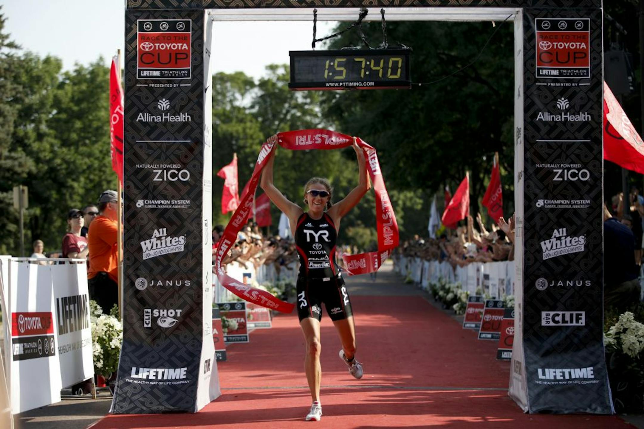 Winner of the Lifetime Fitness Triathlon at Lake Nokomis, Sarah Haskins claims victory as she crosses the finish line breaking the course record at 1.57.50 in Minneapolis, Minn. on Saturday, July 14, 2012.