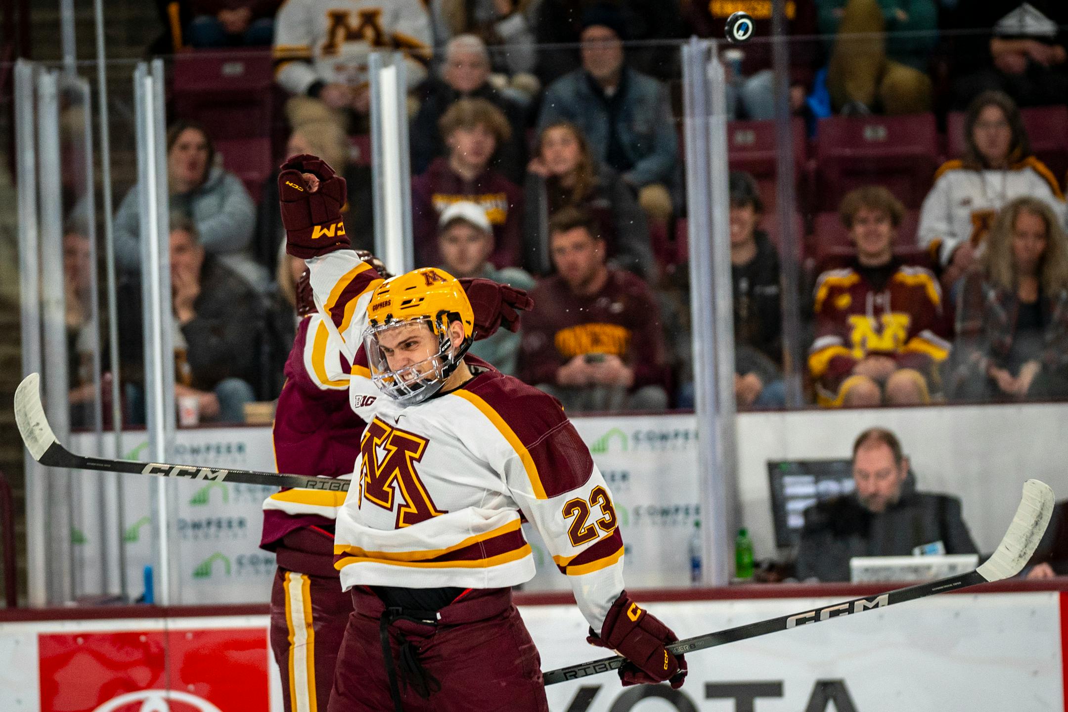 The puck bounces off Minnesota forward Jimmy Clark's (23) helmet.