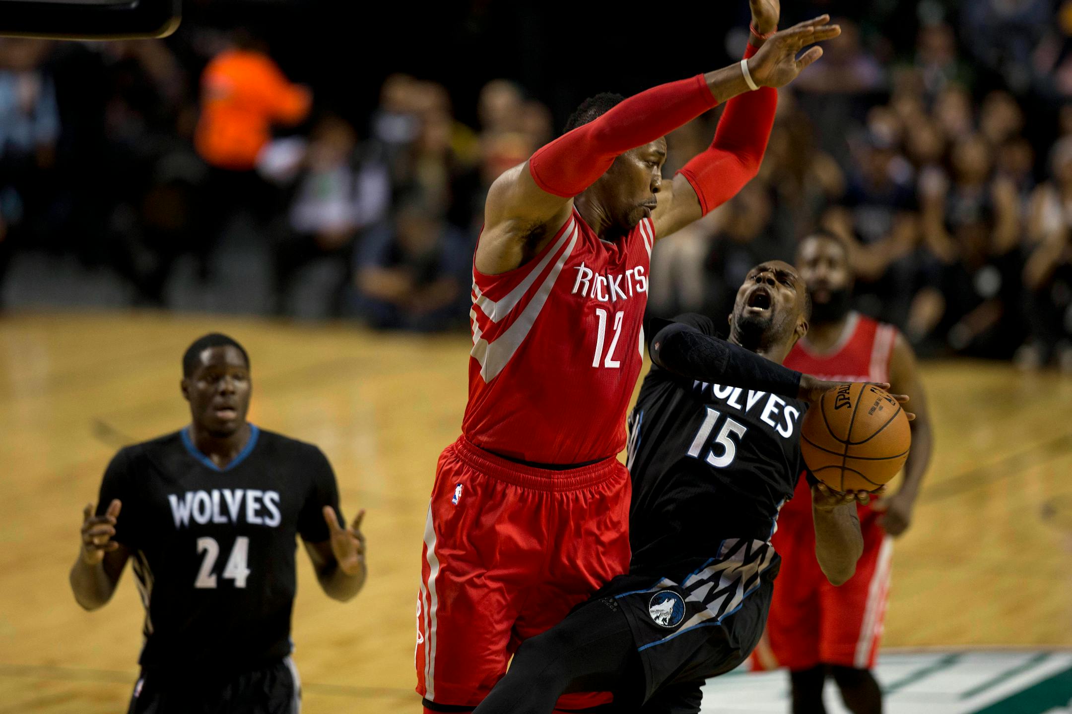 Minnesota Timberwolves' Shabazz Muhammad (15) is fouled by Houston Rockets' Dwight Howard (12) during the first half of an NBA basketball game in Mexico City, Wednesday, Nov. 12, 2014. (AP Photo/Dario Lopez-Mills)
