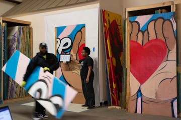 While a mural panel was being photographed, Amira McLendon holds a key that shows where the panel fits in the larger mural Tuesday, March 11, 2025 at