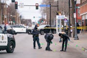Members of the Minneapolis Police Department forensics unit worked around the scene of a multi-person shooting Tuesday near the intersection of E. Fra