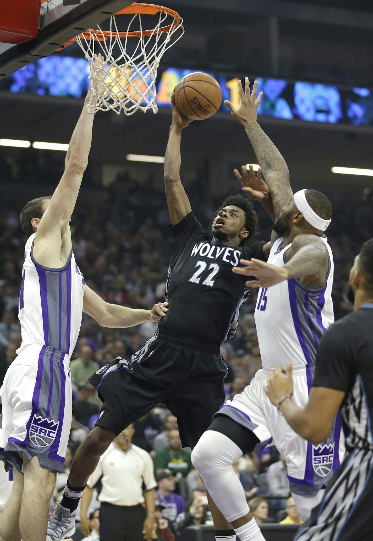 Minnesota Timberwolves forward Andrew Wiggins, center, drives to the basket between Sacramento Kings' Kosta Koufos, left, and DeMarcus Cousins during the first quarter of an NBA basketball game in Sacramento, Calif., Saturday, Oct. 29, 2016. (AP Photo/Rich Pedroncelli)