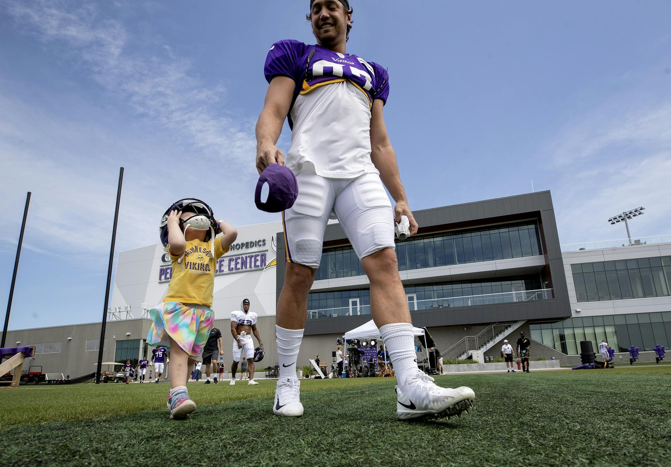 Maria Rekow, 3, of St. Paul, walked out to the practice field wearing the helmet of Minnesota Vikings' Cole Hikutini.