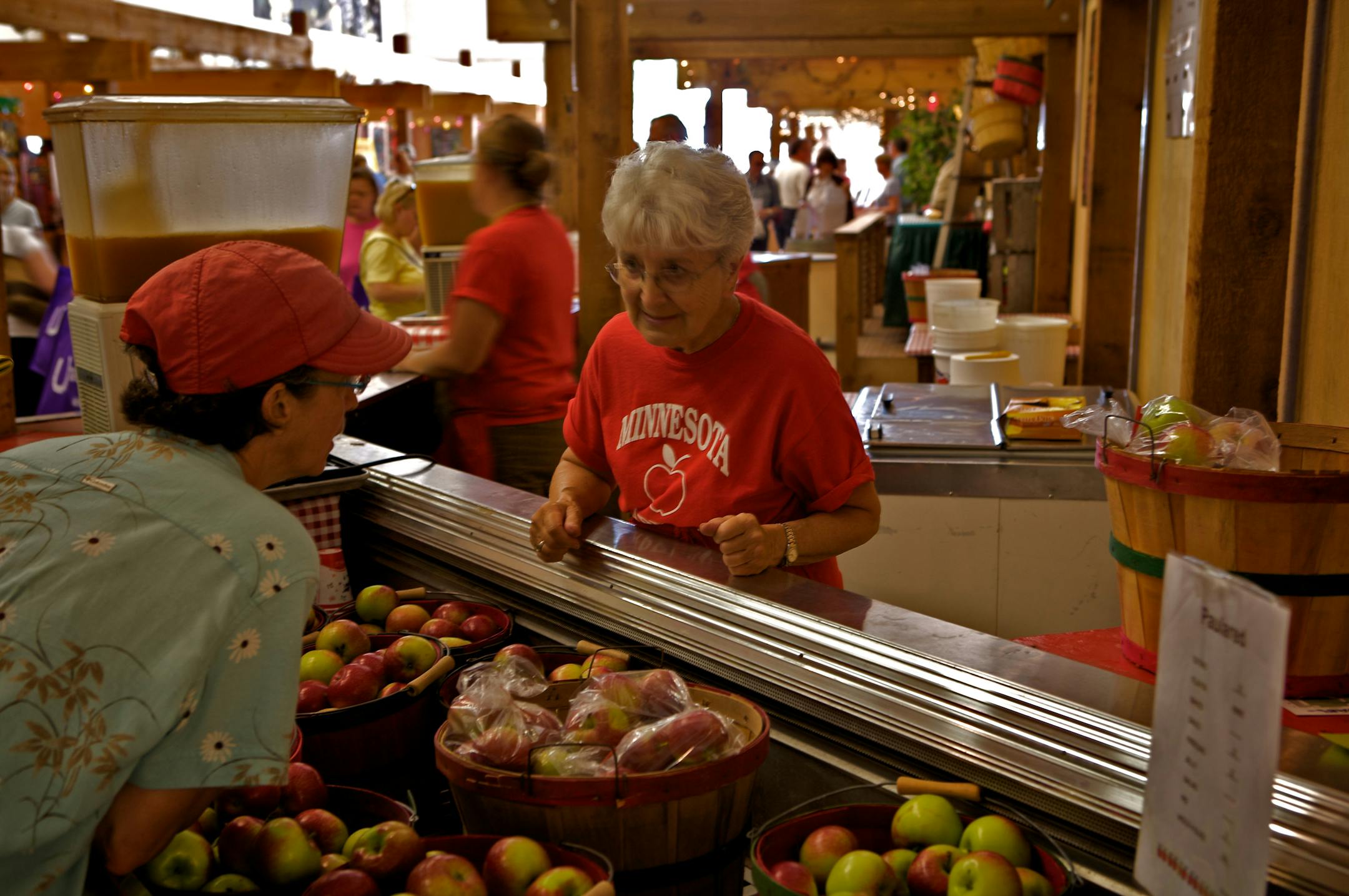 Fairgoer Sharee Marcus, left, talks Paula Reds with Luverne Schmidt at the Minnesota Apples stand.