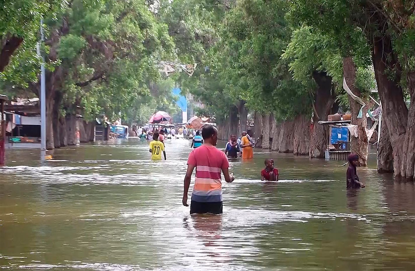 In this image made from video, residents move through floodwaters on a street in the town of Beledweyne, in Somalia Sunday, Nov. 19, 2023. First, some families fled drought and violence. Now they say they have nowhere to hide from intense flooding as rainfall exacerbated by the weather phenomenon El Nino pummels large parts of Somalia. (AP Photo)