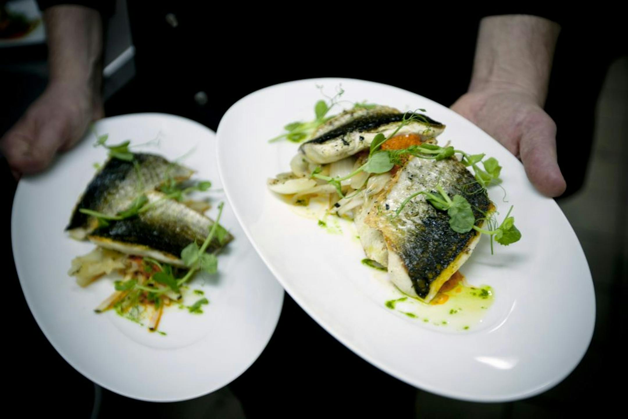 In this Wednesday, April 4, 2012 photo, Israeli chef Noam Dekkers of Liliyot restaurant holds two versions of a fish dish, one kosher for Passover and another served on a piece of bread, right, at a restaurant in Tel Aviv, Israel. The Jewish springtime holiday Passover is known as a festival of freedom, but its hallmark is a litany of dietary restrictions centered on not eating leavened bread for a week. The rules are so elaborate that chefs who want to observe the ritual law must prepare weeks