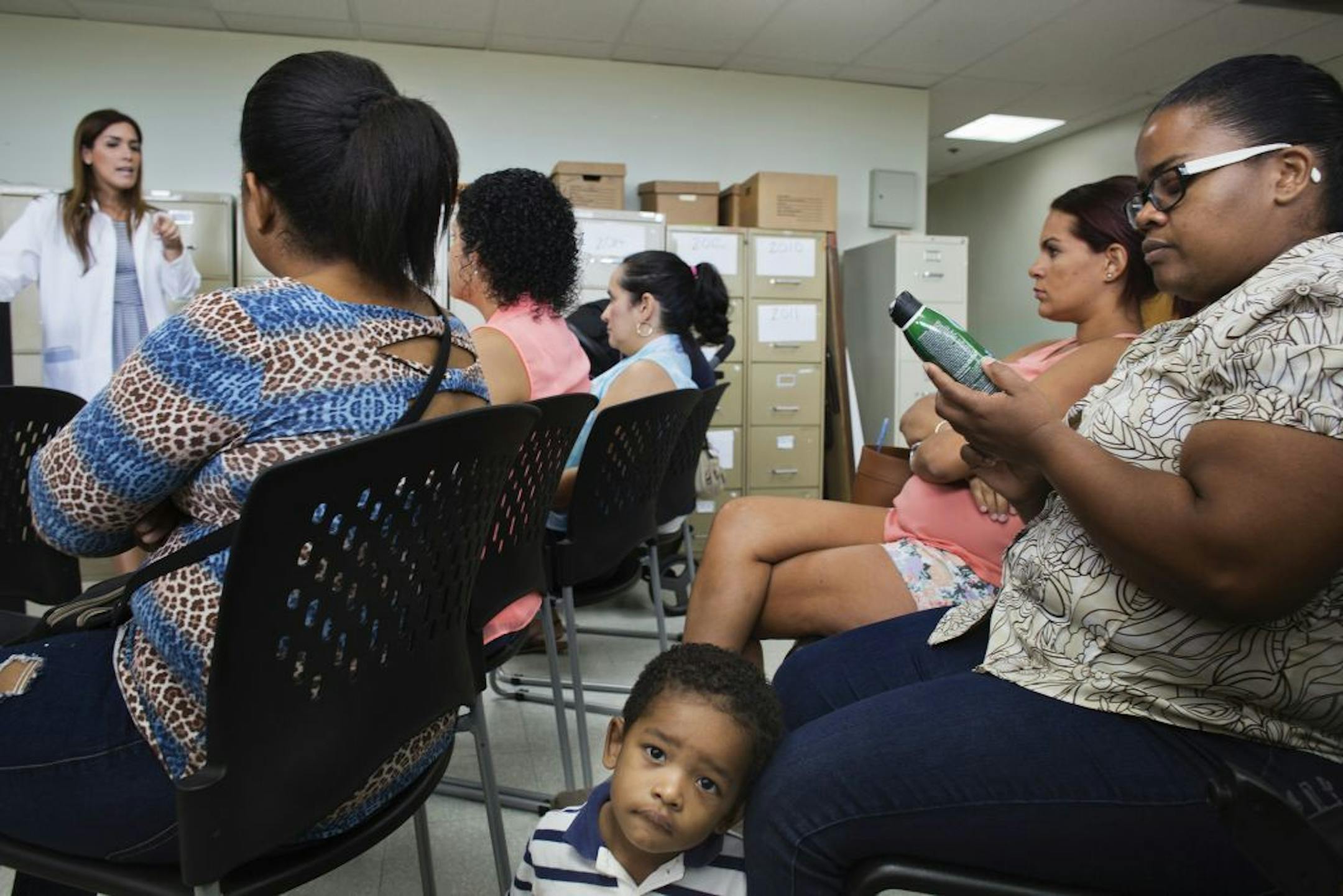 Women and children gather at a clinic for a talk about the Zika virus in Carolina, Puerto Rico, Feb. 25, 2016.