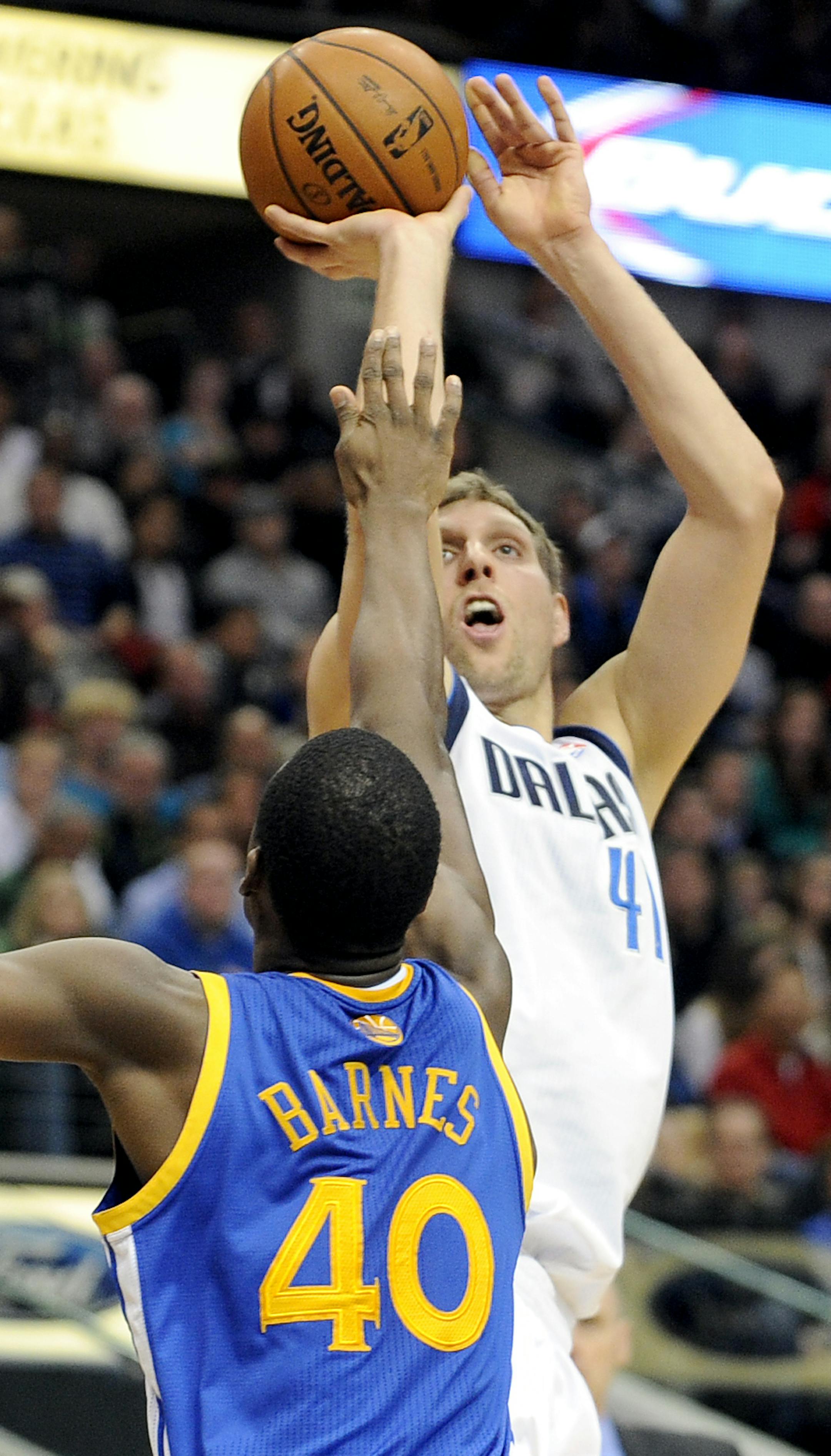 Dallas Mavericks power forward Dirk Nowitzki (41) shoots over Golden State Warriors small forward Harrison Barnes (40) in the first half during an NBA basketball game on Wednesday, Nov. 27, 2013, in Dallas. (AP Photo/Matt Strasen)