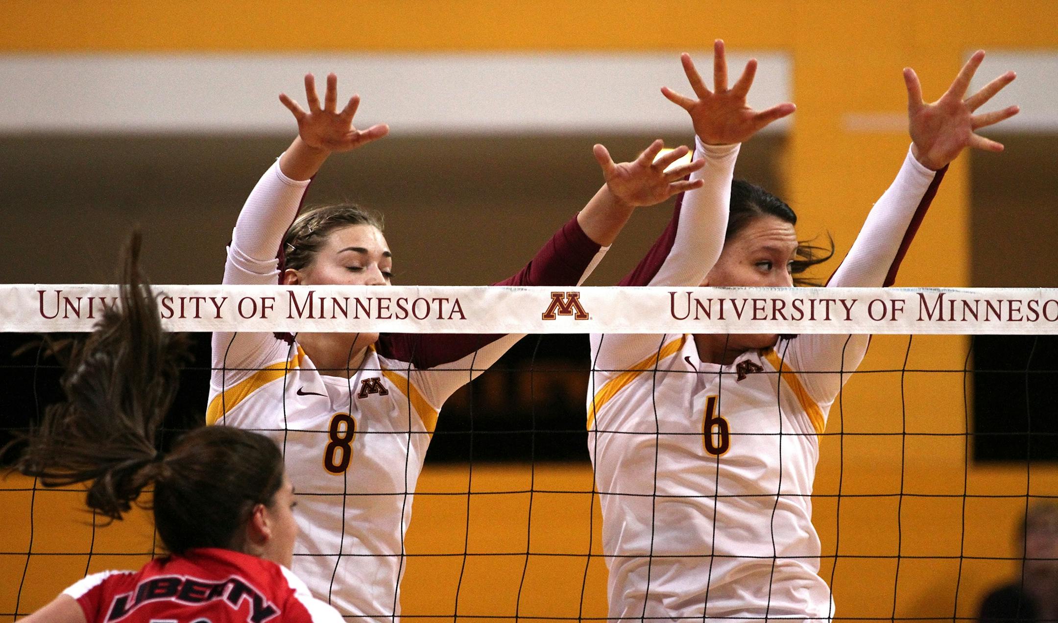 Katherine Harms and Tori Dixon attempted to block the ball after a spike from Liberty during the NCAA tournament.