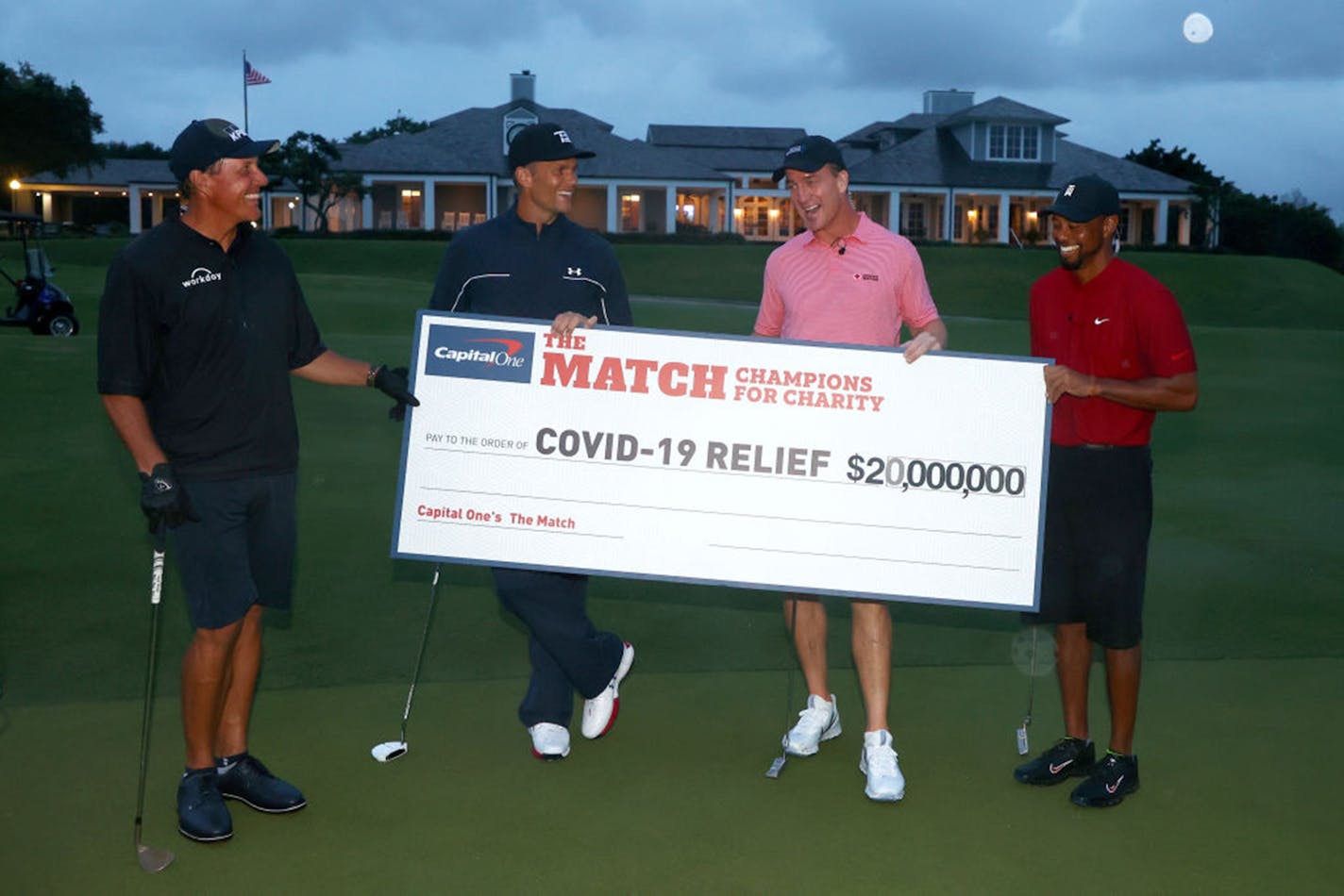 Tiger Woods and former NFL player Peyton Manning celebrate defeating Phil Mickelson and NFL player Tom Brady of the Tampa Bay Buccaneers on the 18th green during "The Match: Champions For Charity"