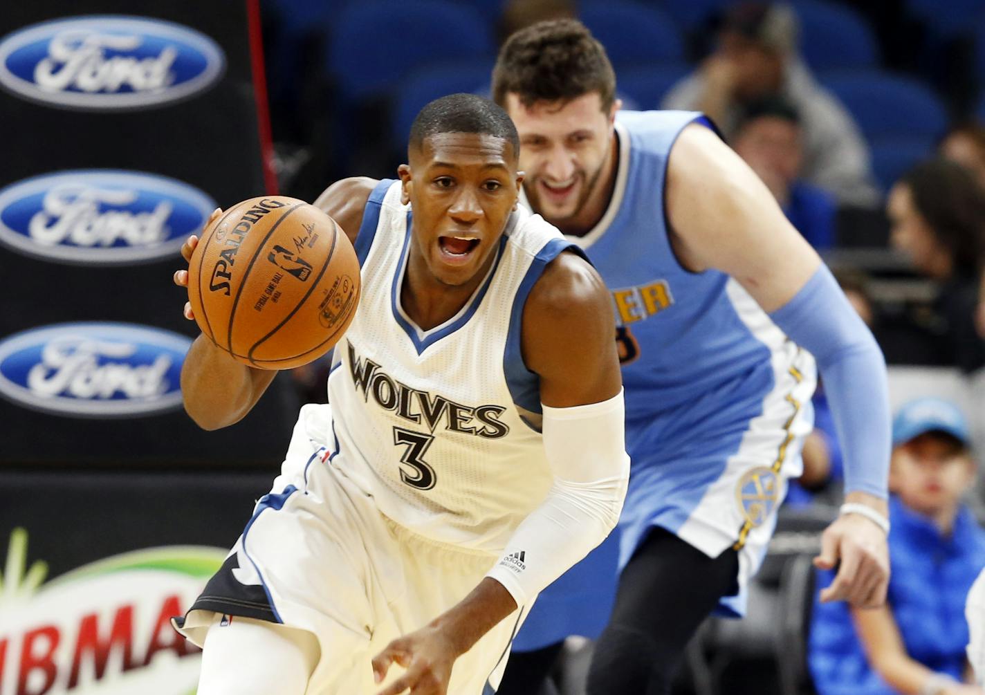 Minnesota Timberwolves' Kris Dunn, left, makes a fast break as Denver Nuggets' Jusuf Nurkic, of Bosnia, pursues in the first quarter of an NBA basketball game Thursday, Nov. 3, 2016, in Minneapolis. (AP Photo/Jim Mone)