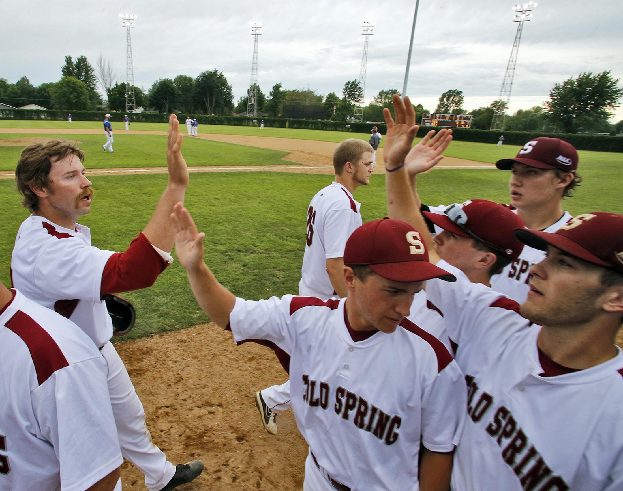 The Cold Spring Springers celebrate the scoring of a run in a game against the Lake Henry Lakers. ] A look at the Cold Spring Springers amateur baseball town team of Cold Spring. The teams have a tradition of family members playing and managing for many years with their children helping out as bat boys and grounds keepers. (MARLIN LEVISON/STARTRIBUNE(mlevison@startribune.com) ORG XMIT: MIN1406300011285714