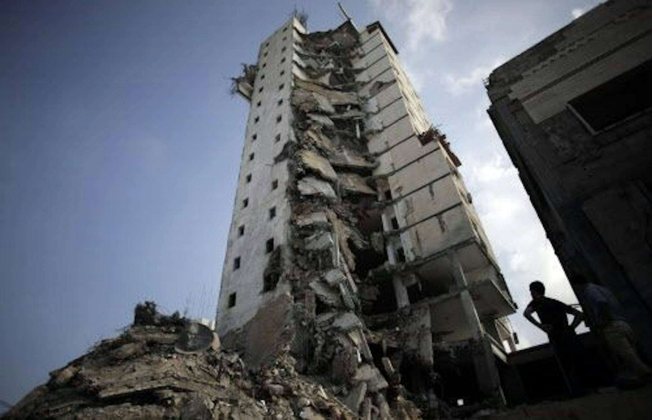 Palestinians inspect the damage to the Italian Complex following several late night Israeli airstrikes in Gaza City, Tuesday, Aug. 26, 2014.