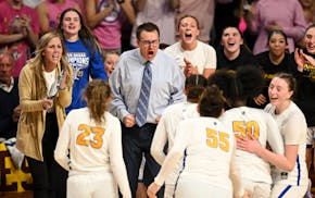 St. Michael-Albertville coach Kent Hamre and his players celebrate a moment last season at state, where his team won the Class 4A title.