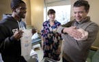 St. Paul Mayor Melvin Carter, left, presented Brianna Heggeseth and her husband Paul Heggeseth with a onesie for their daughter Hanna, who was born at