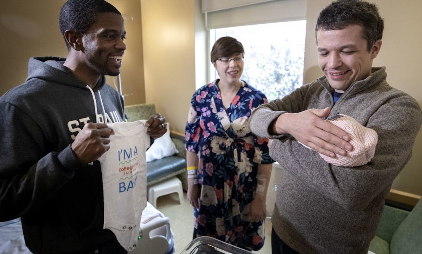 St. Paul Mayor Melvin Carter, left, presented Brianna Heggeseth and her husband Paul Heggeseth with a onesie for their daughter Hanna, who was born at 5:38 am Monday morning.