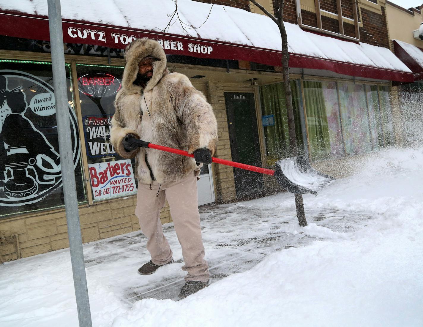 Barber Jimmy Bynum, who owns Cutz Too on Lake Street, had a coyote-fur coat to help ward off blowing snow and another shot of winter Tuesday, Jan. 10, 2016, in Minneapolis.