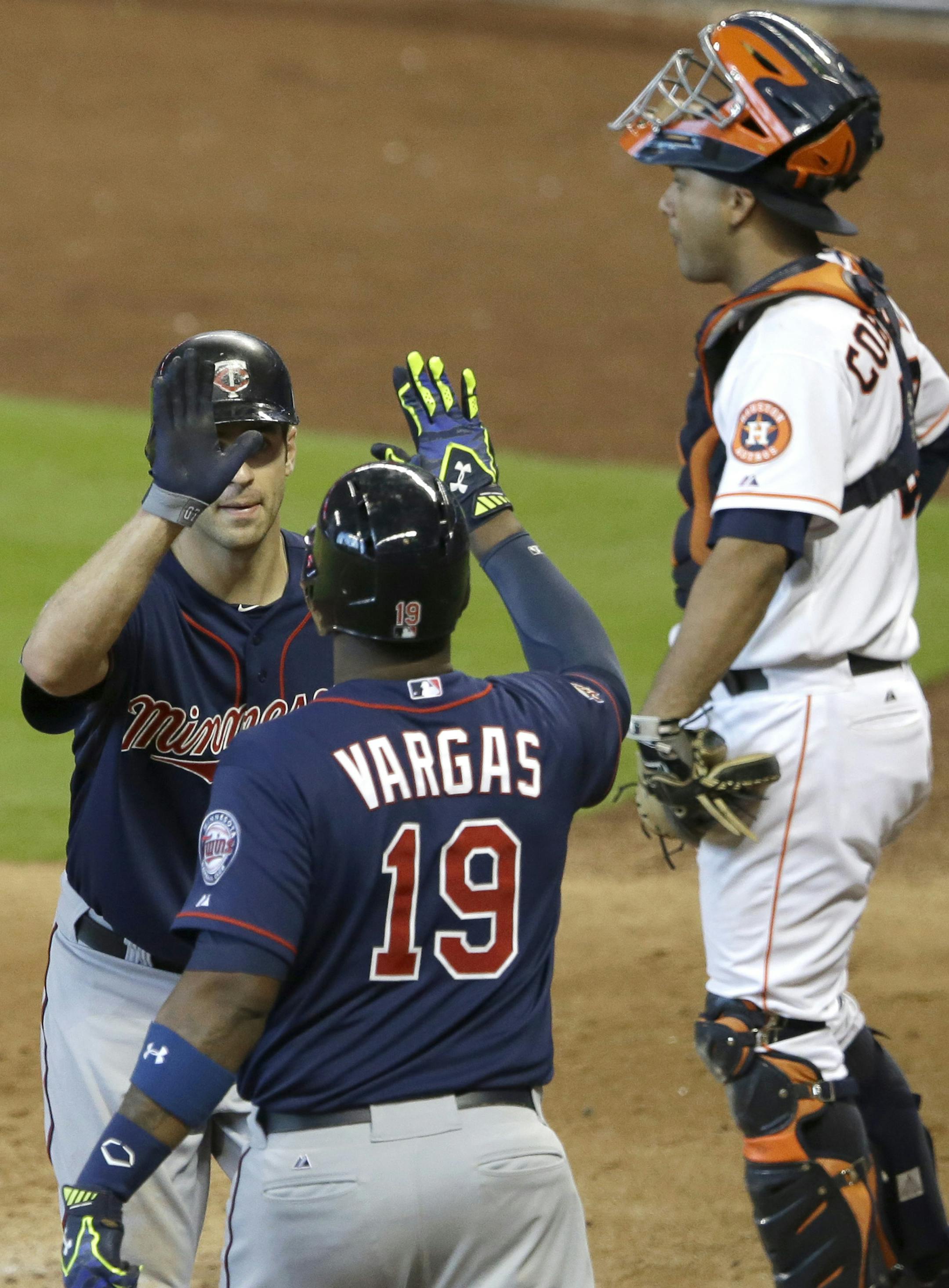Minnesota Twins' Joe Mauer, left, is congratulated by Kennys Vargas (19) on a solo homer as Houston Astros catcher Carlos Corporan, right, looks off in the sixth inning of a baseball game Wednesday, Aug. 13, 2014, in Houston. (AP Photo/Pat Sullivan)