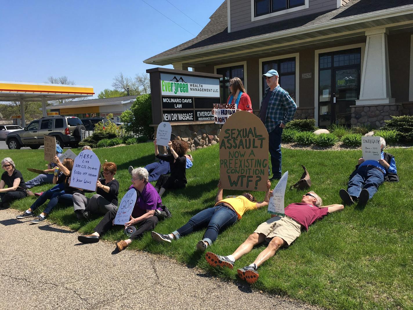 Demonstrators stage a "Die-In" outside of Rep. Jason Lewis's district office in Burnsville, Minn. on May 5, 2017.