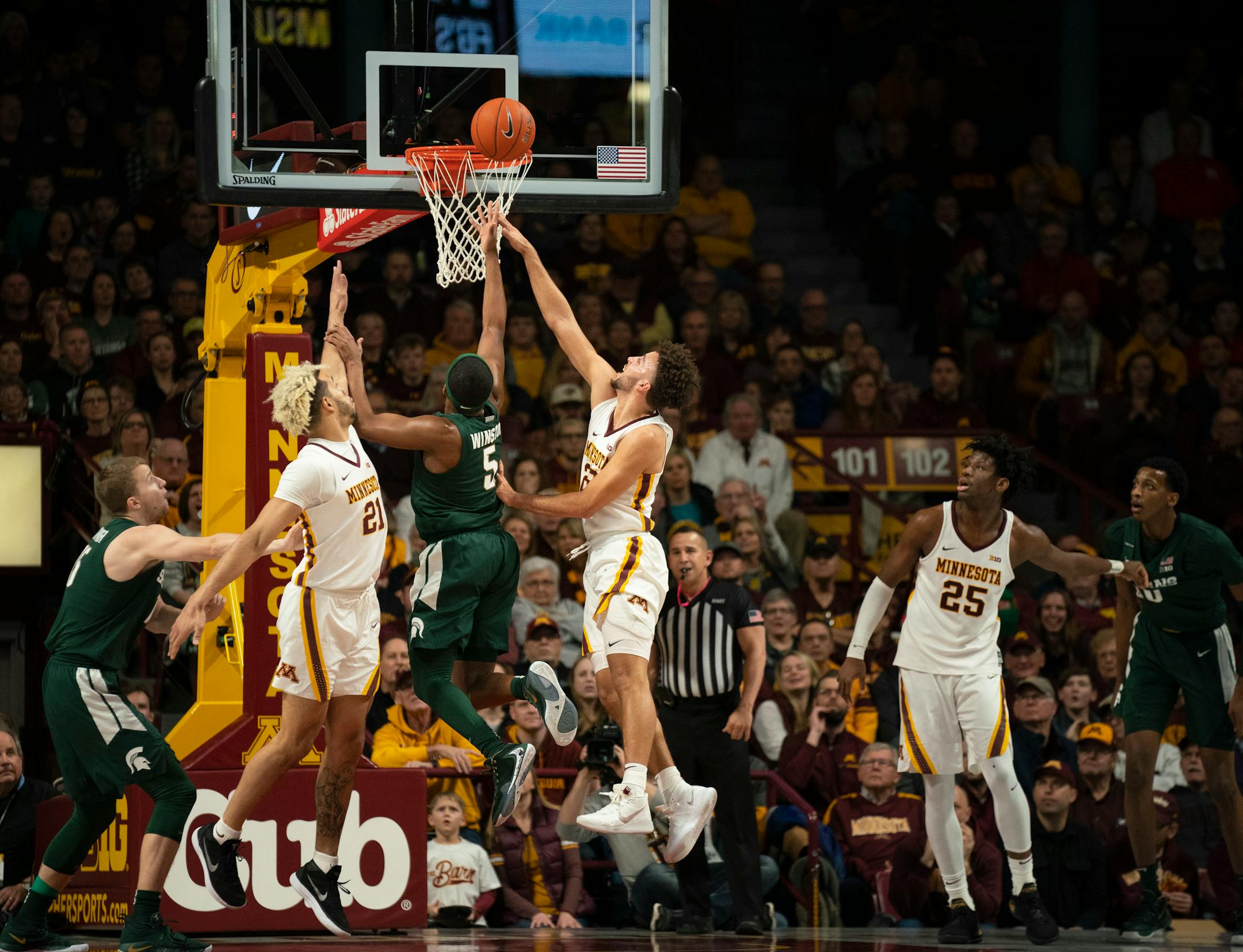 Michigan State guard Cassius Winston scored in the first half between the defense of Gophers forward Jarvis Omersa, left, and guard Gabe Kalscheur. Winston led the No. 11 Spartans with 18 points in their 70-52 victory at Williams Arena on Sunday.