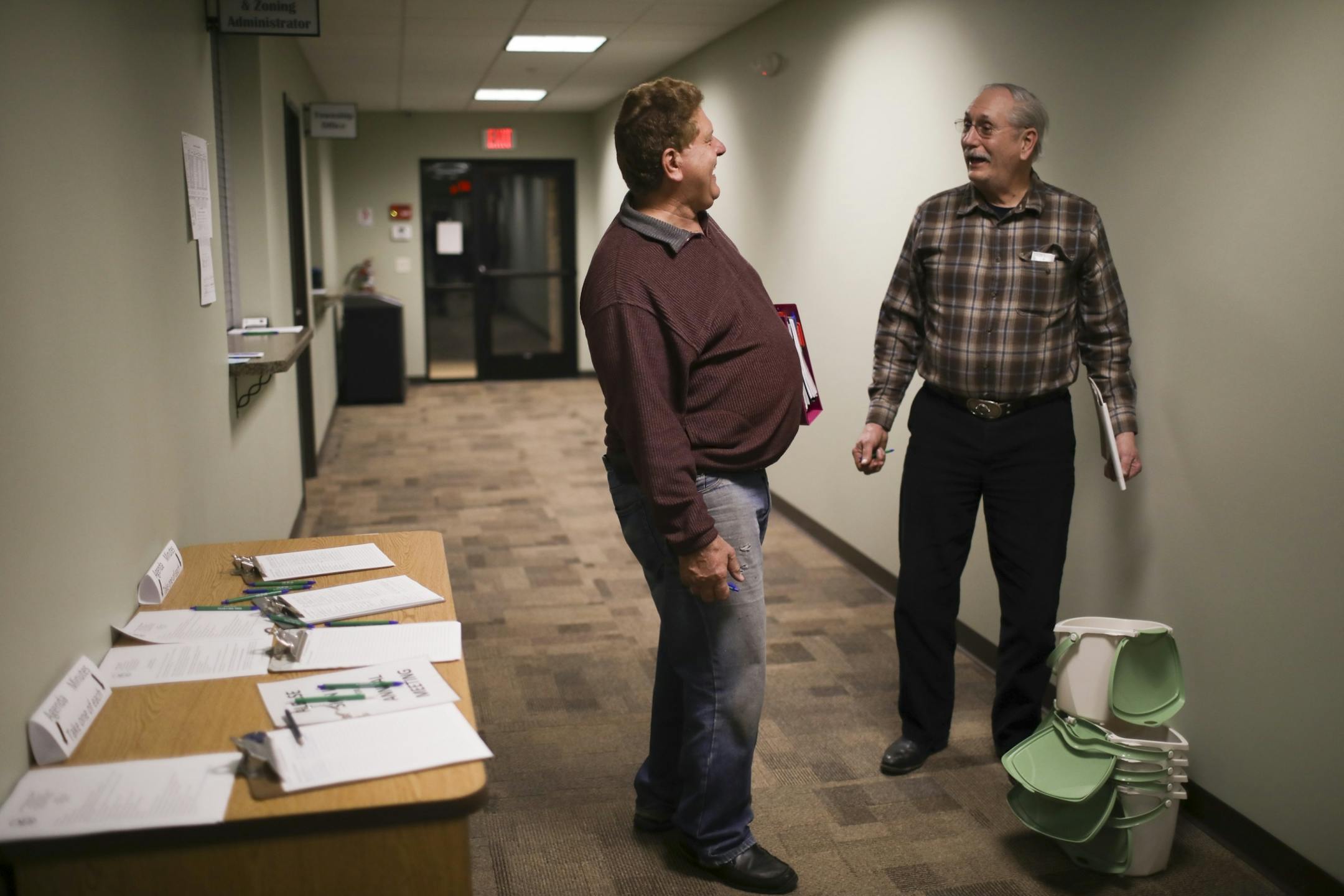 Ed Kramer, right, visited with Tim Peterson, a Linwood Township Supervisor, in the hallway after the annual meeting. The township is beginning recycling of organics and Kramer, the township recycling coordinator, was poised to hand out containers for resident who wanted them as they left the annual meeting.
