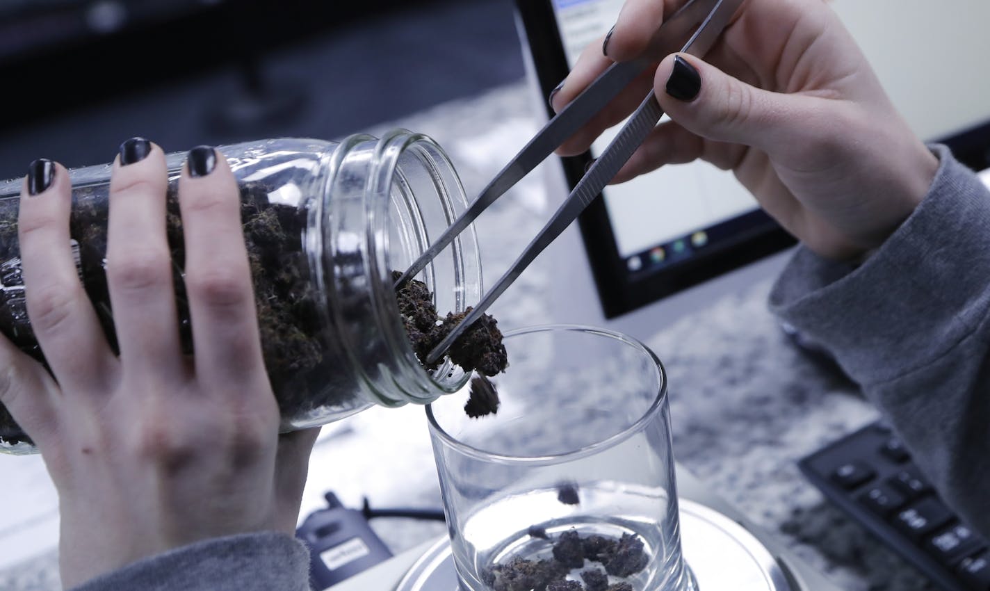 An attendant weighs marijuana at the Far West Holistic Center dispensary, Wednesday, Nov. 7, 2018, in Detroit. Michigan voters have made their state the first in the Midwest to legalize recreational marijuana. Voters passed a ballot measure Tuesday that will allow people 21 or older to use the drug. North Dakota voters decided recreational pot wasn't for them, Missouri voters passed one of three unrelated measures legalizing medical marijuana and voters in Utah were also considering a medical ma