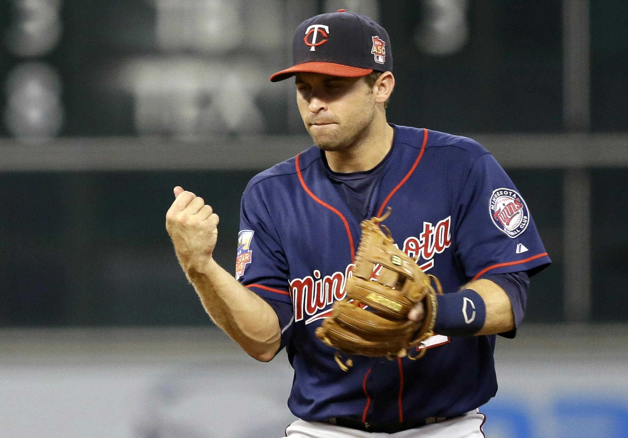 Minnesota Twins second baseman Brian Dozier pumps his fist after the Twins completed a double play against the Houston Astros to end the second inning of a baseball game Monday, Aug. 11, 2014, in Houston.