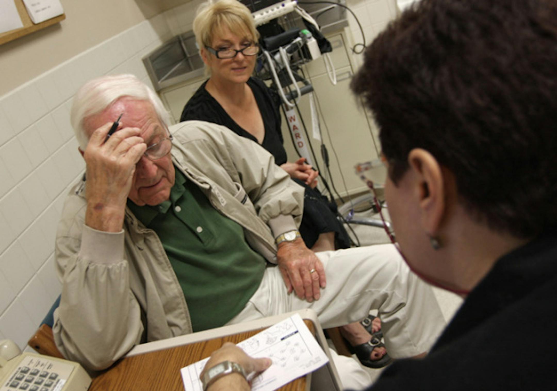 John Wagner, 82, worked out questions given by Maria Cofrancesco to assess his condition. His daughter, Lisa Wagner, back, said despite the Alzheimer's diagnosis, the family is glad for the support and information offered as part of the VA program.